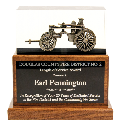 Antique steam fire pumper embedded in clear acrylic, mounted on solid walnut base