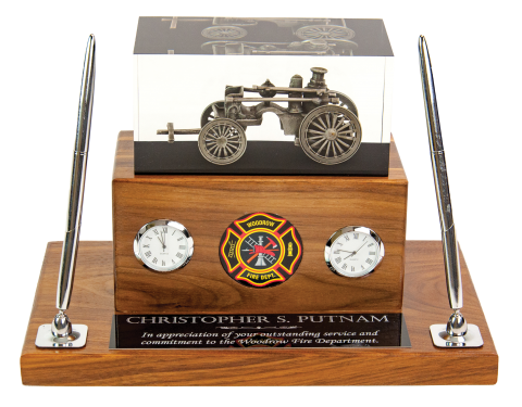 Antique steam fire pumper embedded in clear acrylic, mounted on solid walnut base; includes 2” medallion, clock, hygrometer, and two pen set.
