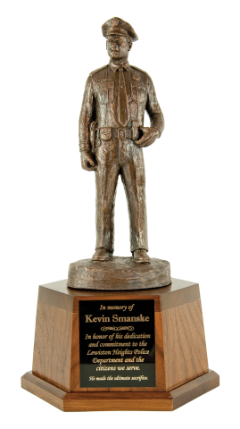 Statue of a police officer standing at attention cast in bronze.