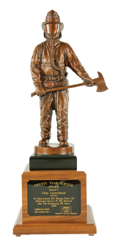 Bronze finished firefighter, cast resin with axe, mounted on sold walnut base with engraved plate.